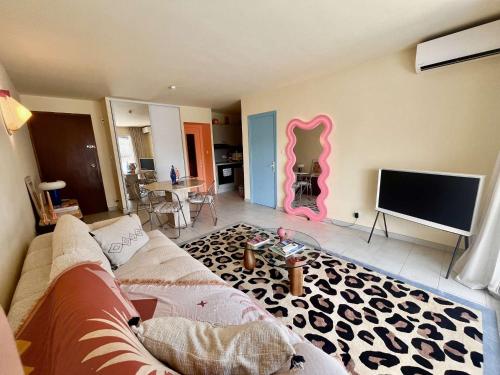 un salon avec un canapé et une télévision à écran plat dans l'établissement Appartement rénové 1 chambre à Cavalaire, proche plage, climatisé avec parking - FR-1-226B-107, à Cavalaire-sur-Mer