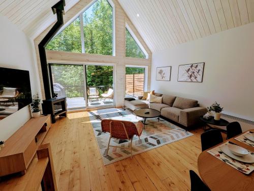 a living room with a couch and a table at Chalet au Mont-Édouard, Les 3 Versants 38B in LʼAnse-Saint-Jean