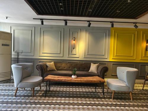 un salon avec un canapé et deux chaises dans l'établissement The Şişli PP Beijng Suites and Noodle House, à Istanbul