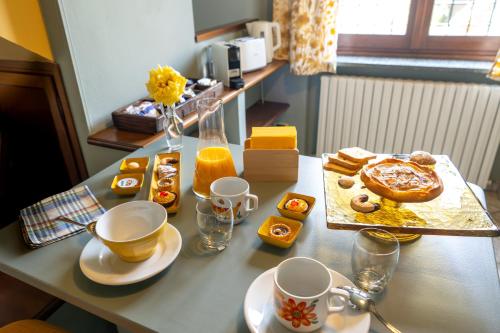 a table with a breakfast of pastries and orange juice at Il Nido di Adele in Gavi