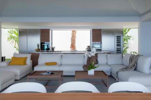 a living room with a white couch and tables at Sparkling Water Villa with Calming Ocean Views in Quartier de Lorient