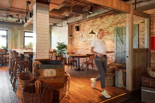 a woman is running in a room with a brick wall at Lighthouse Hotel & Spa in Büsum