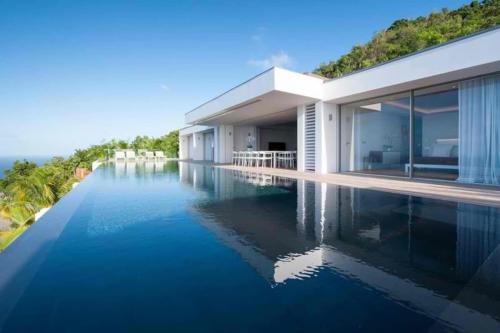 a house with a swimming pool in front of it at Sparkling Water Villa with Calming Ocean Views in Quartier de Lorient