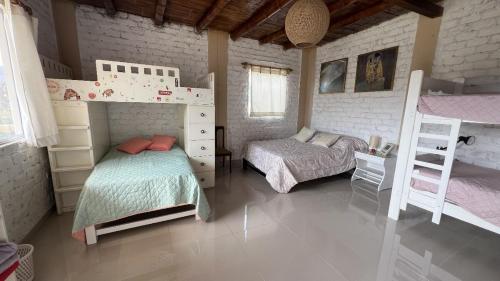 une chambre avec deux lits superposés dans une pièce dans l'établissement Casa campo vista linda, à Mala