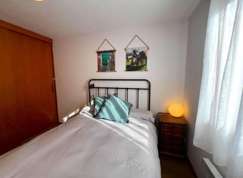 une chambre avec un lit avec un oreiller bleu dessus dans l'établissement Apartamento con piscina y Wifi en Santa Leocadia, à Sainte-Léocadie