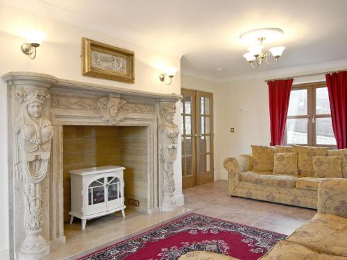 a living room with a couch and a fireplace at Magnolia Cottage in Aberaeron