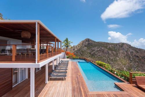 a villa with a swimming pool and a mountain at Serene Sea View Oasis Close to Lorient Beach in Quartier de Lorient
