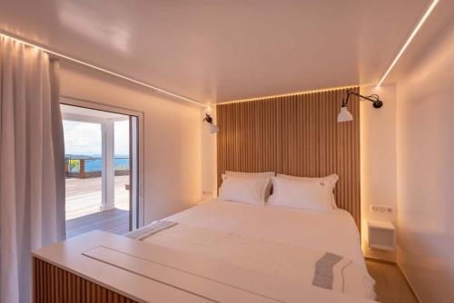 a bedroom with a large white bed and a window at Serene Sea View Oasis Close to Lorient Beach in Quartier de Lorient