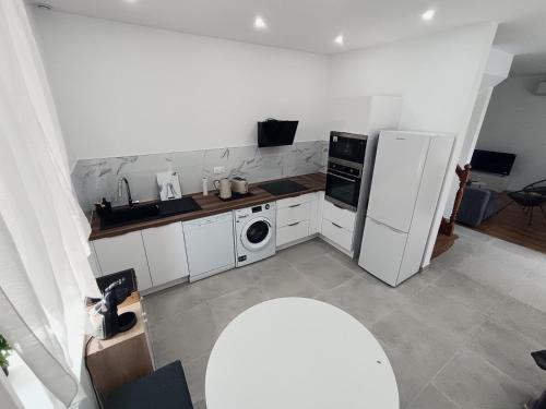 a kitchen with a white refrigerator and a dishwasher at La Parenthèse Verte - Garden - Air conditioning - Near center in Romilly-sur-Seine