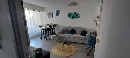 un salon avec un canapé et une table dans l'établissement Appartement T2 bord de mer, à Canet