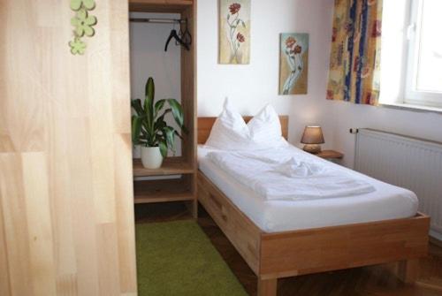 una camera da letto con un letto con lenzuola bianche e una pianta di I AM HOTEL Graz-Seiersberg a Graz