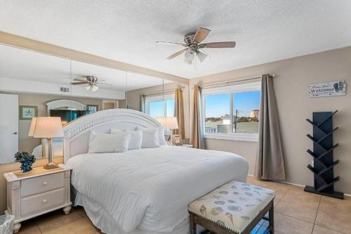 een slaapkamer met een wit bed en een plafondventilator bij Aqua Villa #405 in Fort Walton Beach