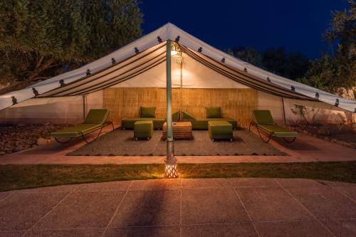 a tent with a couch and chairs under it at Havre de Paix à Marrakech in Heddad