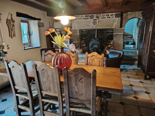 une salle à manger avec une table et des chaises et une cheminée dans l'établissement Jonael, à Scrignac