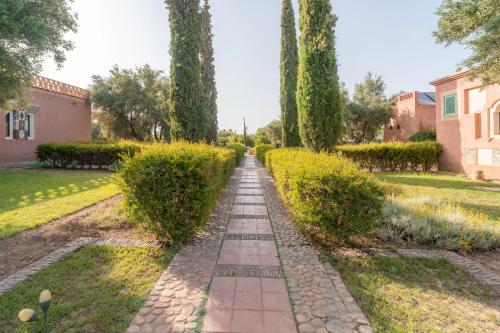 a stone path in a garden with trees at Havre de Paix à Marrakech in Heddad
