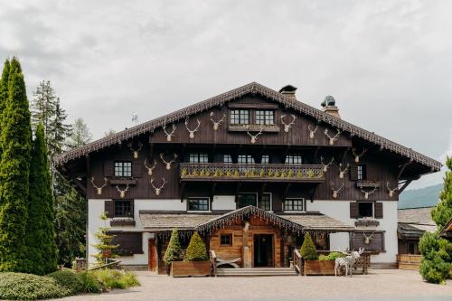 une grande maison en bois avec un toit en gambrel dans l'établissement Les Chalets du Mont d'Arbois & Spa, Megève, à Megève