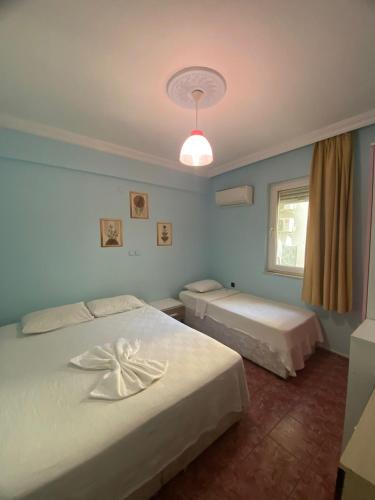 a bedroom with two beds and a window at Şato Apart Hotel in Fethiye