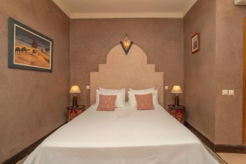 a bedroom with a large white bed with two lamps at Havre de Paix à Marrakech in Heddad