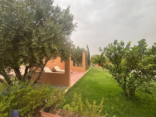 a garden with a bench in the grass at Villa Marrackech Sbai in Oubadine