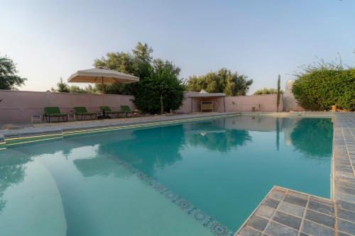 a large swimming pool with blue water at Havre de Paix à Marrakech in Heddad