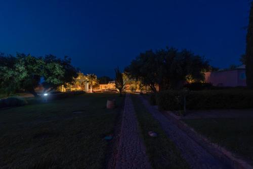 a night view of a yard with trees and a street at Havre de Paix à Marrakech in Heddad