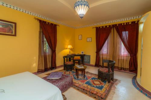 a bedroom with a bed and a table and chairs at Havre de Paix à Marrakech in Heddad