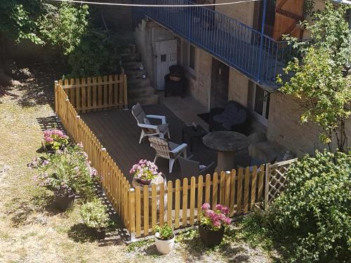 a backyard with a wooden fence and a table and chairs at La Petite Maison du Gardien in Sainte-Agnès