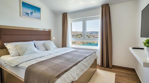 ein Schlafzimmer mit einem großen Bett und einem großen Fenster in der Unterkunft Vila Romana by Resort Čulina in Metajna