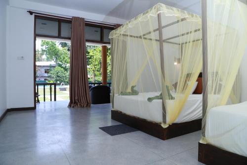 a bedroom with a canopy bed with curtains at The Grand Yala Hotel in Tissamaharama