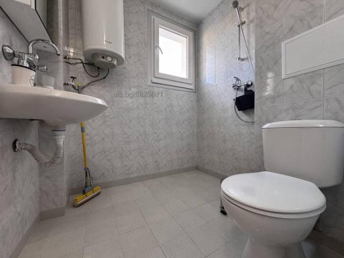a bathroom with a toilet and a sink at Апартамент Плажен рай in Burgas City