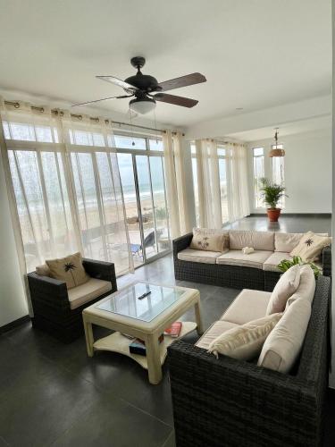 a living room with couches and a ceiling fan at Casa Palmar Oceanfront paradise in Zorritos in Zorritos