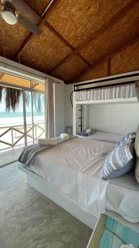 a bedroom with a large bed with a view of the ocean at Casa Palmar Oceanfront paradise in Zorritos in Zorritos