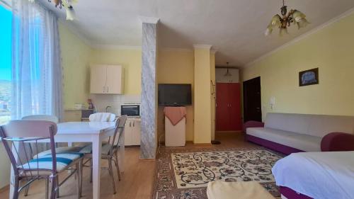 una cucina e un soggiorno con tavolo e sedie di Zana's Apartment a Pogradec