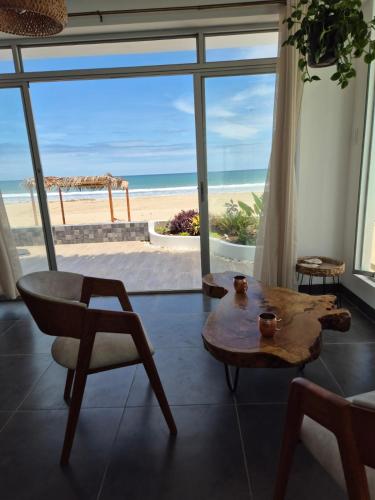 a living room with a table and a view of the beach at Casa Palmar Oceanfront paradise in Zorritos in Zorritos