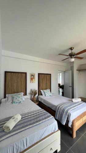 a bedroom with two beds and a ceiling fan at Casa Palmar Oceanfront paradise in Zorritos in Zorritos