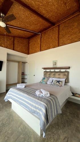 a bedroom with a large bed with a wooden ceiling at Casa Palmar Oceanfront paradise in Zorritos in Zorritos