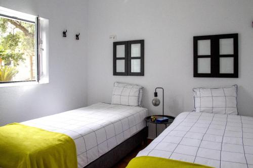 a bedroom with two beds and a window at Casas Porta Alegre in Portalegre