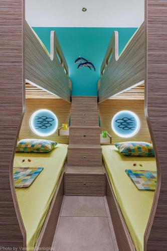 two beds in a room with two windows at Costa Petra - Luxury Seaside Cottage with Garden - Vacation House for families in Greece in Néa Meságkala