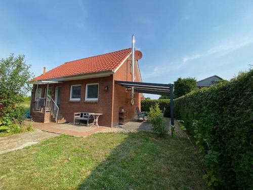 a small house with a picnic table in the yard at Ferienhuus En Söten in Bedekaspel