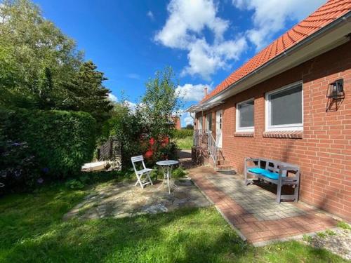 a patio with a table and a bench in the yard at Ferienhuus En Söten in Bedekaspel