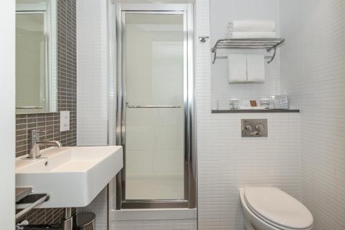 a bathroom with a shower and a toilet and a sink at DoubleTree by Hilton Hotel London - Tower of London in London