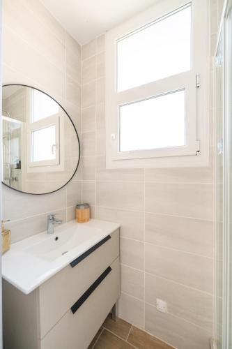 une salle de bain avec un lavabo et un miroir dans l'établissement Bandol - Appartement Corneille, à Bandol