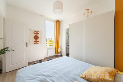a bedroom with a bed and a window at Bandol - Appartement Corneille in Bandol