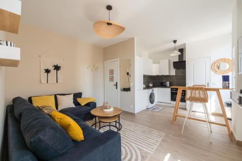 a living room with a blue couch and a kitchen at Bandol - Appartement Corneille in Bandol