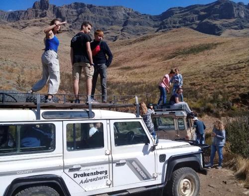 a group of people standing on top of a white jeep at Sani Lodge & Cottages in Sani Pass