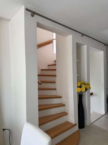 a staircase in a house with a vase of flowers at Relaxing Stay by the Beach in Ayvalık