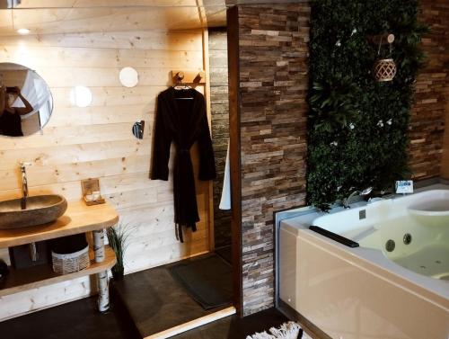 a bathroom with a tub and a sink at L'Idylle Moment de Détente in Nay