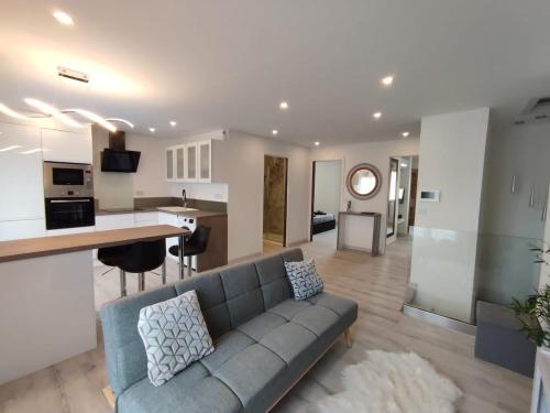 a living room with a couch and a kitchen at Appartement proche mer, climatisé, netflix in Argelès-sur-Mer