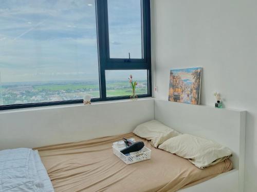 un lit dans une chambre blanche avec une fenêtre dans l'établissement Cố Đô Homestay, à Thôn Văn Dương