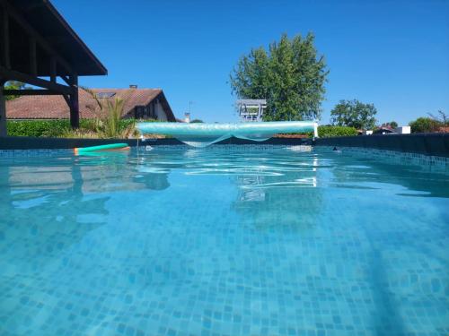 une piscine avec un toboggan bleu à l'intérieur dans l'établissement Gîte des Lauriers Roses - Piscine collective, Spas et jardins privés - 7 kms de la plage de Lespecier, à Bias